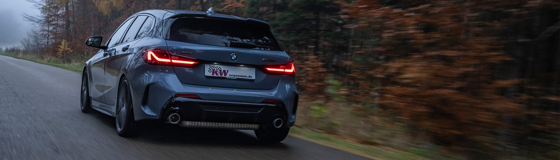 BMW M135i xDrive on rain-wet road with installed KW Variant 3 coilover suspension kit.